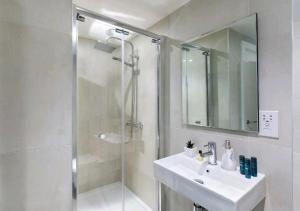 伦敦Deluxe Central London North Apartment的白色的浴室设有水槽和淋浴。
