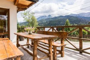考斯赛力克Domy Sywarne z Sauną i widokiem na góry的山景阳台上设有一张木桌和长凳