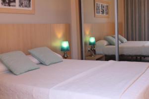 维拉Advise Hotels Reina的一间卧室配有一张带两盏灯的大型白色床。