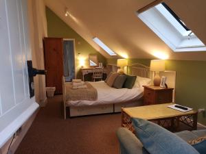 莱姆里吉斯Kersbrook Guest Accommodation的一间卧室配有一张床和一个沙发