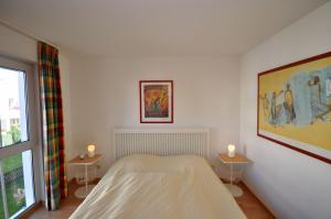 萨斯尼茨Komfort-Ferienwohnung Meeresrauschen by Meer-Ferienwohnungen的一间卧室配有一张床和两张带蜡烛的桌子。