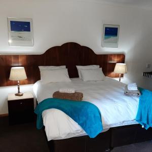 上瓦特法尔Wayside Lodge的一间卧室配有一张大床和木制床头板