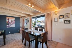 陶波Fenworth - Taupo Holiday Home的一间带桌椅和窗户的用餐室
