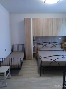 圣阿尔坎杰洛-迪罗马涅La Casina的一间卧室配有两张床、一张桌子和一把椅子