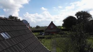 腓特烈斯科格Ferienhaus Krabbenloch Friedrichskoog的房屋旁边的一个田野里的红色谷仓