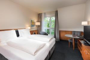 莱比锡Seminaris Hotel Leipzig的酒店客房设有两张床和电视。