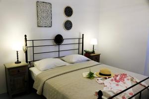 Mandrakia爱琴海蓝色度假屋的一间卧室,配有一张床,上面有帽子