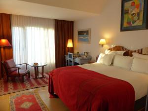 拉巴特拉威拉蔓特林酒店的酒店客房设有一张带红色毯子的大床