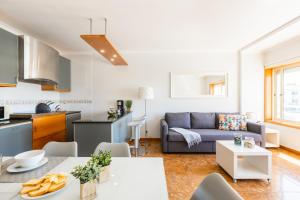 ArcozeloAguda Beach Apartment的厨房以及带沙发的起居室。