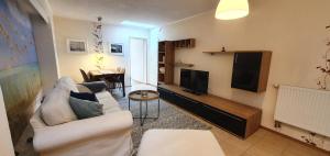 奥斯赛拜-屈隆斯博恩Pension Zum Riedensee的客厅配有白色沙发和电视