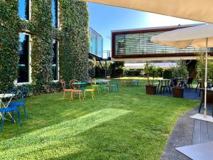 卡米尼亚Design & Wine Hotel的一座带桌椅的庭院和一座建筑