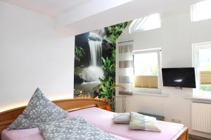 梅德巴赫施魏因博格公寓式酒店的一间卧室配有一张床,墙上挂着瀑布壁画