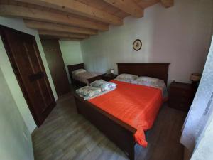 CerciventoBuine Tiere的一间卧室配有两张带橙色毯子的床
