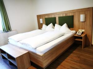 施图拜河谷新施蒂夫特贝格维尔特宾馆的一间卧室配有一张大床和木制床头板