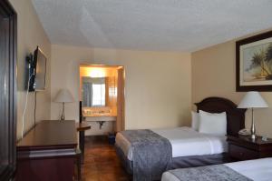 奥兰多Altamonte Springs Hotel and Suites的酒店客房设有两张床和电视。