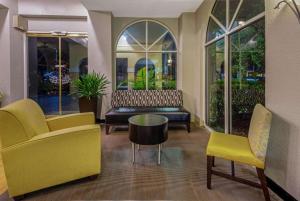 迈阿密湖迈阿密湖拉金塔旅馆及套房的大堂设有黄色椅子、长凳和桌子
