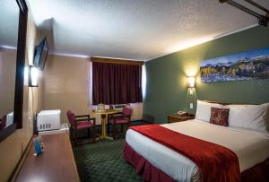 SiltRed River Inn Silt - Rifle的酒店客房设有一张大床和一张桌子。
