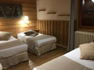 拉普德兹阿祖尔阿尔卑斯酒店的酒店客房,设有两张床和木墙