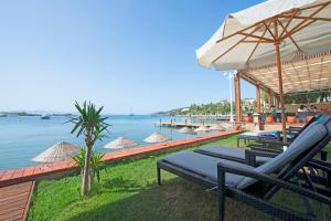 居姆贝特卡斯塔路维酒店 - 全包式的水边的度假胜地,配有椅子和遮阳伞