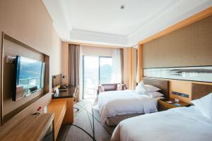 景德镇景德镇西山湖凯莱度假酒店的酒店客房设有两张床和一台平面电视。