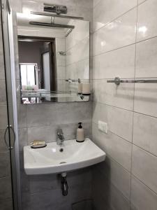 敖德萨Apartments Ilona的白色的浴室设有水槽和镜子