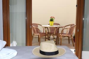 波罗斯Dimitra Boutique Hotel的坐在桌椅顶上的帽子