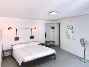 洛迦诺Great2Stay City Center Apartments的白色卧室配有床和风扇