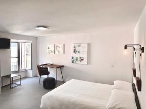 洛迦诺Great2Stay City Center Apartments的白色卧室配有床和书桌