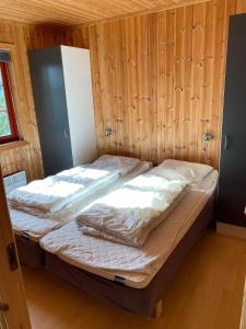 哈山Hafjell Grenda lejligheder的木制客房内的一间卧室配有两张床