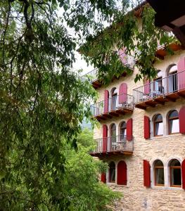 加尔达湖滨La Berlera - Riva del Garda的一座建筑,设有红色的门和阳台