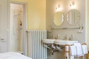 米伦雷吉纳酒店的浴室设有2个盥洗盆和带镜子的淋浴。