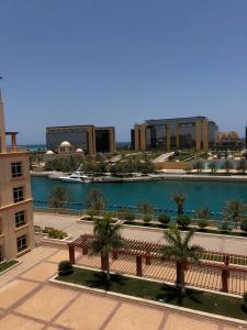 阿卜杜勒国王经济城شقة مارينا البيلسان - عائلات فقط的享有带长凳和水体的建筑的正面景色