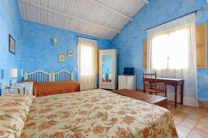 马尔萨拉Podere Fossarunza di Carlo Manzo的蓝色卧室配有床、书桌和床罩