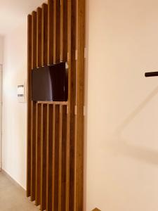 阿凡杜阿吉若乡村公寓式酒店的客房内的木墙上配有电视
