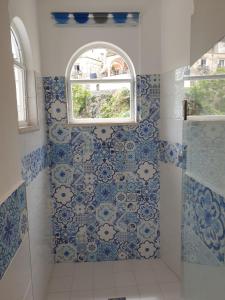 波西塔诺Regina Margherita的浴室铺有蓝色和白色的瓷砖,设有窗户。