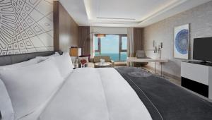 多哈InterContinental Doha Beach & Spa, an IHG Hotel的酒店客房设有一张大床和一张书桌。