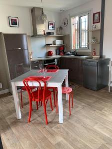 布科·莱斯白老城Appartement Résidence Saint Jours - Centre ville的厨房配有桌子和四把红色椅子