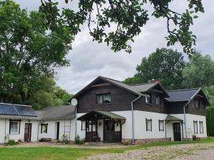克鲁克兰基Siedlisko nad Sapiną的黑色屋顶的大型白色房屋