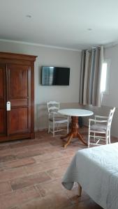 巴纽勒森林Au Relais Provencal的客厅配有桌椅和电视。