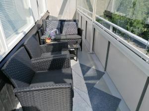 锡林耶尔维City centre apartment Siilinjärvi的阳台配有两把椅子、一张桌子和一张沙发