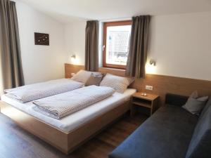 圣洛伦佐-迪塞巴托Pramstaller Apartments的一间卧室设有两张床和窗户。