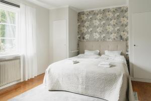 SvärdsjöTrollnäs Hotell的卧室配有白色床和花卉壁纸