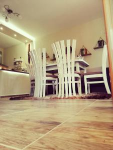 特里亚夫纳Petrov Apartment的一张桌子的房间里一组白色的椅子