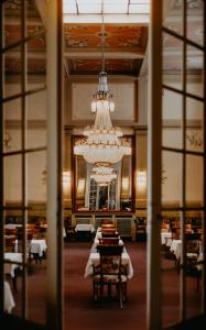 巴特基辛根维多利亚凯瑟霍夫酒店的一间带吊灯和桌椅的用餐室