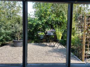 阿尔克马尔Holiday Home Canal View的享有种植了盆栽植物的花园美景的窗户