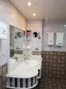 阿尔布亚米Alsafa Hotel的浴室配有水槽、浴缸和毛巾