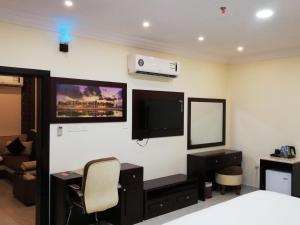 阿尔布亚米Alsafa Hotel的一间卧室配有一张床、一张书桌和一台电视。