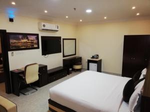 阿尔布亚米Alsafa Hotel的配有一张床和一台平面电视的酒店客房