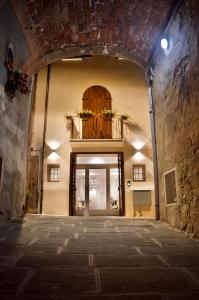拉戈堡Hotel Boutique Castiglione del Lago的通往大楼的入口,设有门和阳台