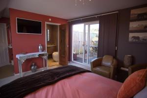 查希尔Birdsong Cottage Bed and Breakfast的一间卧室设有一张床和一个滑动玻璃门